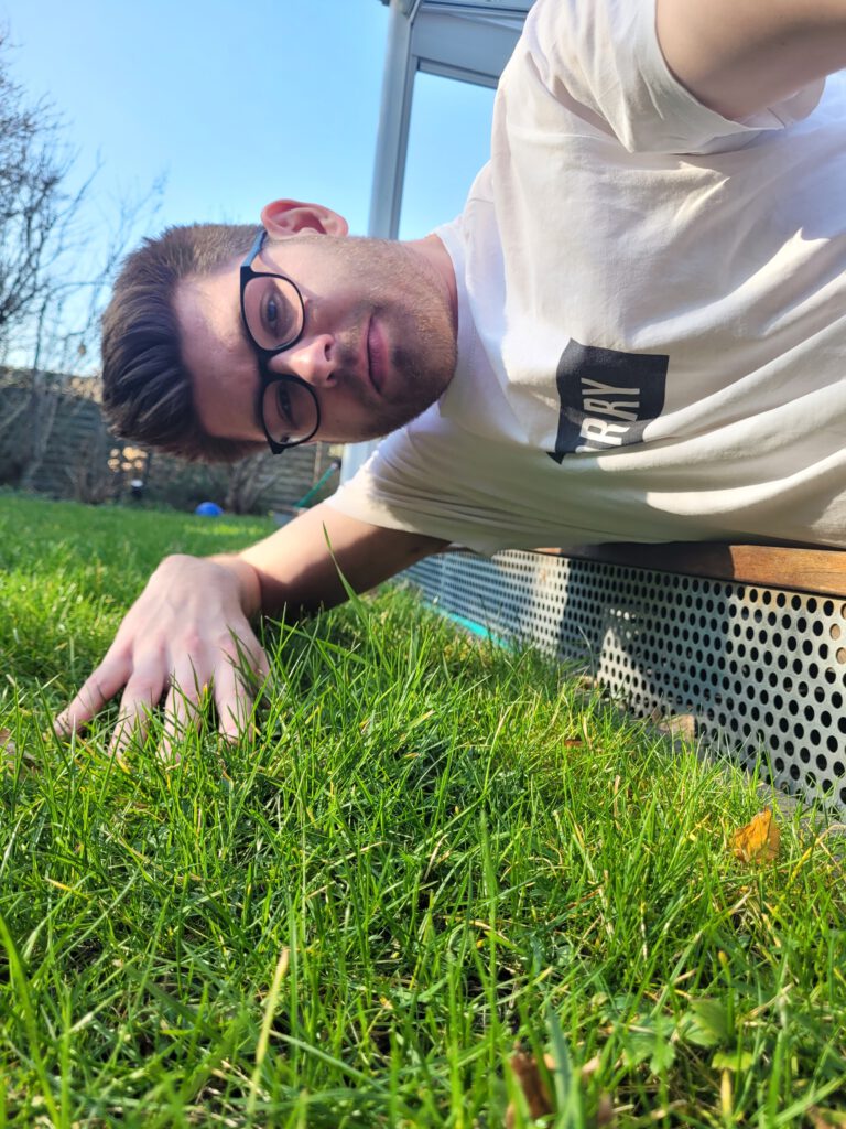 Bild von Julian Schrewe wie er Gras anfasst